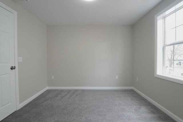 empty room with baseboards and carpet