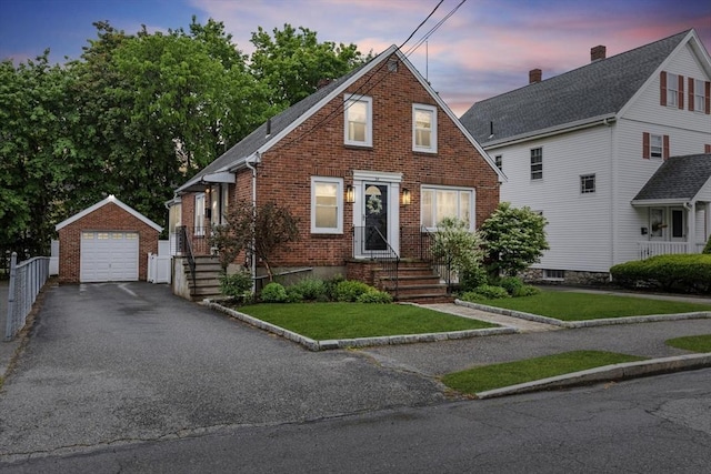 24 Armory St, Wakefield, MA 01880 - bungalow-style house with brick siding, an outbuilding, a garage, asphalt driveway, and a lawn