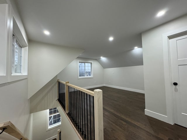 hall with dark wood-type flooring and lofted ceiling