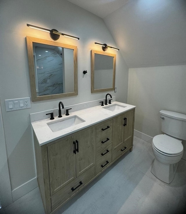 bathroom with vanity, vaulted ceiling, and toilet