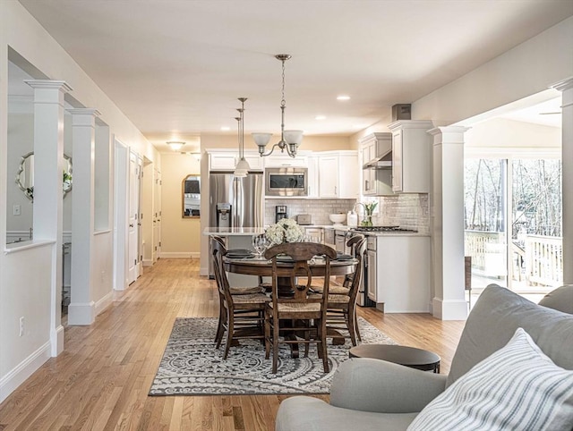 dining area featuring light hardwood / wood-style floors and decorative columns