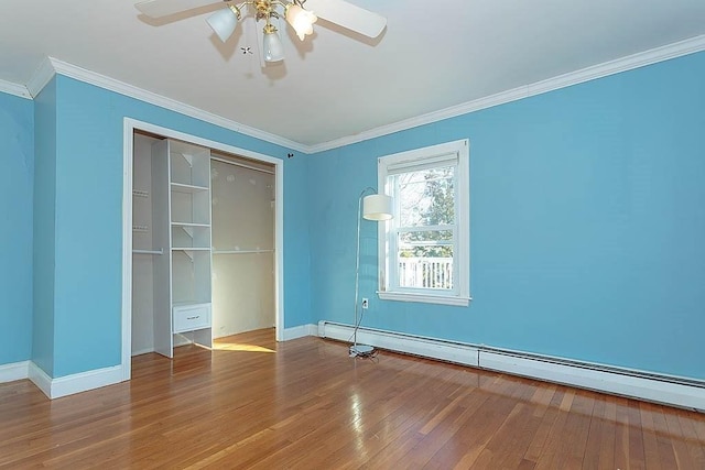 unfurnished bedroom featuring wood finished floors, baseboards, a baseboard radiator, ornamental molding, and a closet