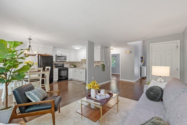 263 Meeting House Path Unit 263, Ashland, MA 01721 - living room featuring wood finished floors, baseboards, and a chandelier