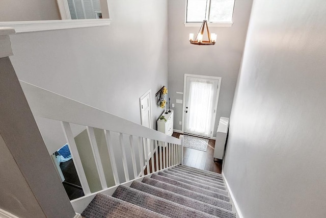 263 Meeting House Path Unit 263, Ashland, MA 01721 - stairs with a chandelier, a towering ceiling, baseboards, healthy amount of natural light, and wood finished floors