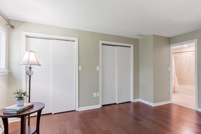263 Meeting House Path Unit 263, Ashland, MA 01721 - unfurnished bedroom with two closets, wood finished floors, and baseboards