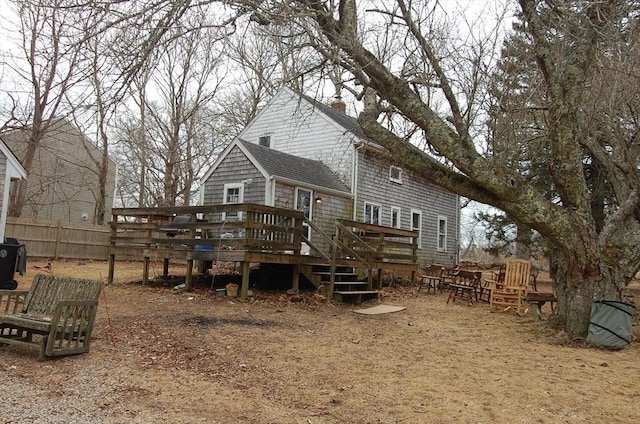 back of house with a chimney, fence, and a deck