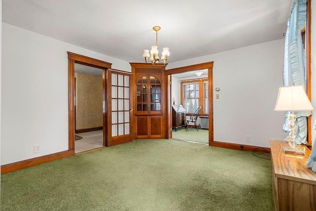 empty room featuring carpet floors and a chandelier