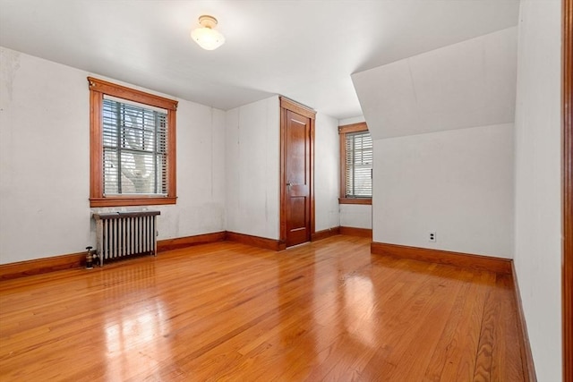 bonus room with light hardwood / wood-style flooring, radiator, and plenty of natural light