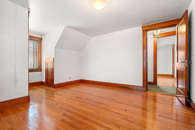 bonus room with lofted ceiling and light hardwood / wood-style flooring