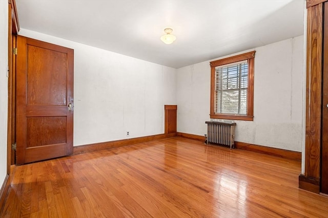 empty room with radiator heating unit and light wood-type flooring