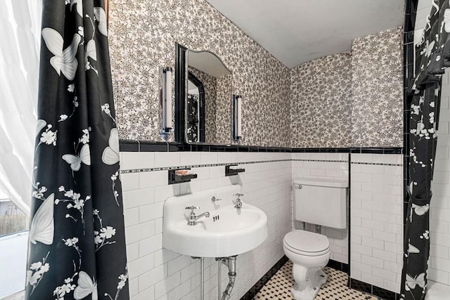 bathroom with tile walls, tile patterned flooring, sink, and toilet