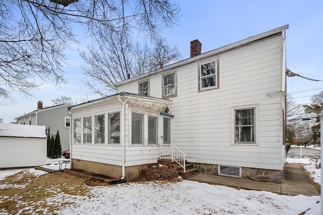 snow covered property featuring a sunroom