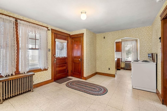 entryway with washer / dryer, radiator heating unit, and plenty of natural light