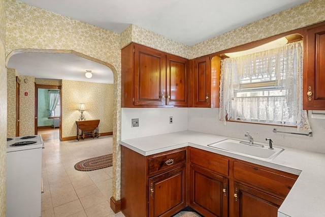 kitchen with electric range, light tile patterned floors, and sink