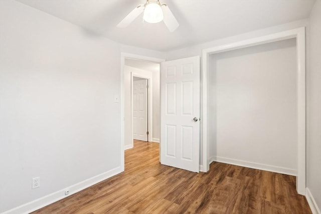 unfurnished bedroom with ceiling fan, dark hardwood / wood-style floors, and a closet