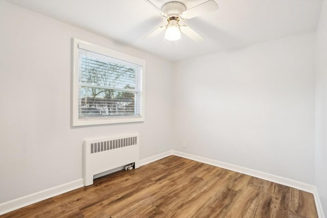 unfurnished room featuring hardwood / wood-style floors, radiator, and ceiling fan