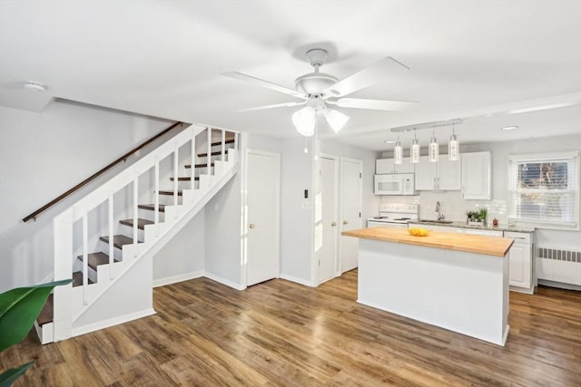 kitchen with white cabinetry, radiator heating unit, wood counters, wood-type flooring, and white appliances