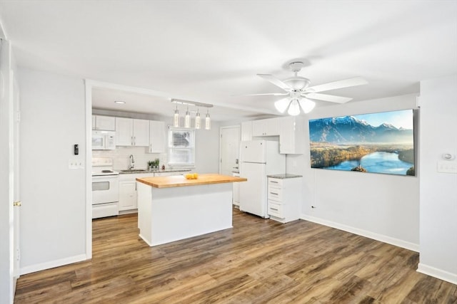 kitchen featuring white cabinets, white appliances, a kitchen island, and butcher block counters