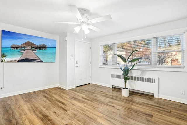 foyer with radiator, ceiling fan, and wood-type flooring