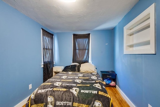 bedroom with wood-type flooring and a textured ceiling