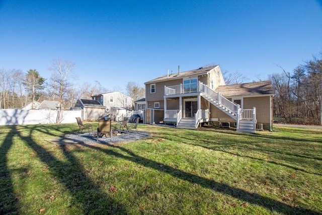 back of house featuring a wooden deck and a lawn