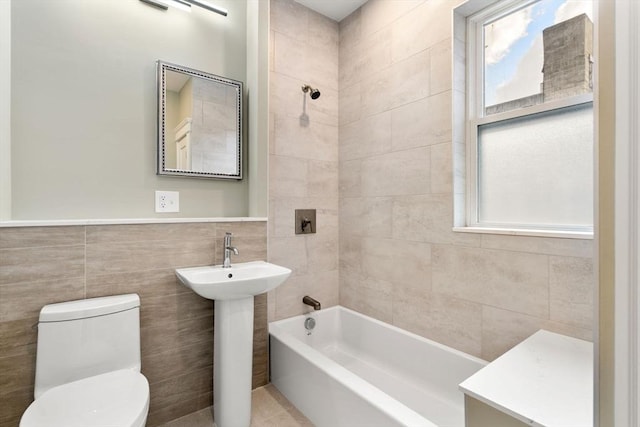 132 Sewall St Unit C, Brookline, MA 02446 - bathroom featuring toilet, tile walls, tub / shower combination, and a sink
