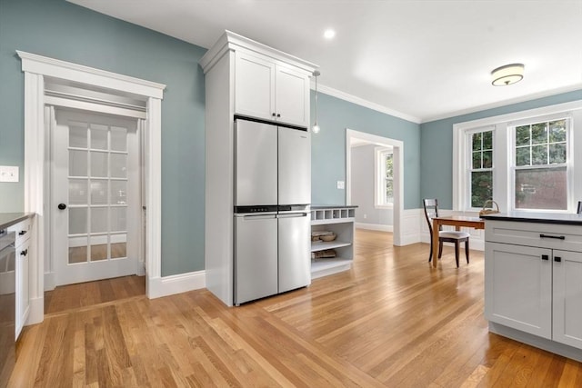 132 Sewall St Unit C, Brookline, MA 02446 - kitchen featuring stainless steel appliances, light wood finished floors, ornamental molding, baseboards, and white cabinets
