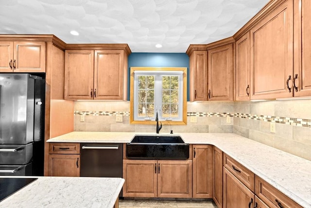 kitchen with dishwasher, light stone countertops, refrigerator, backsplash, and sink