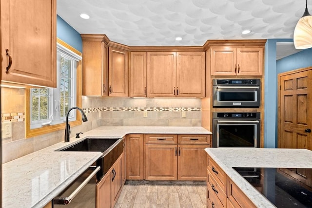 kitchen with hanging light fixtures, sink, backsplash, stainless steel dishwasher, and black electric stovetop