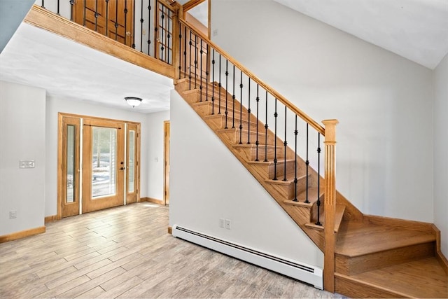 stairway with hardwood / wood-style flooring, high vaulted ceiling, and a baseboard heating unit