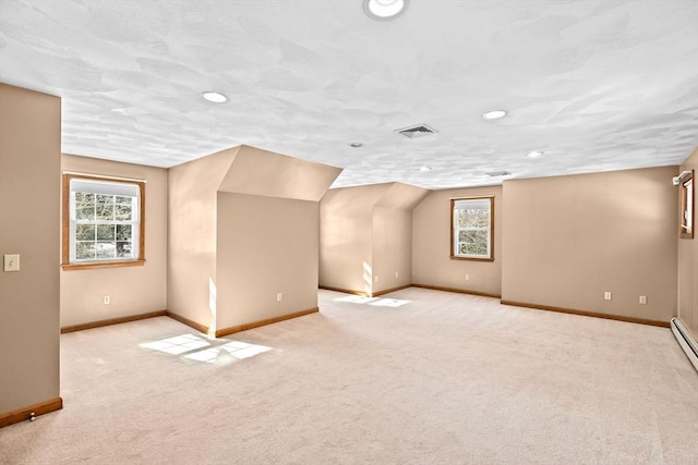 bonus room featuring vaulted ceiling, light carpet, and a textured ceiling