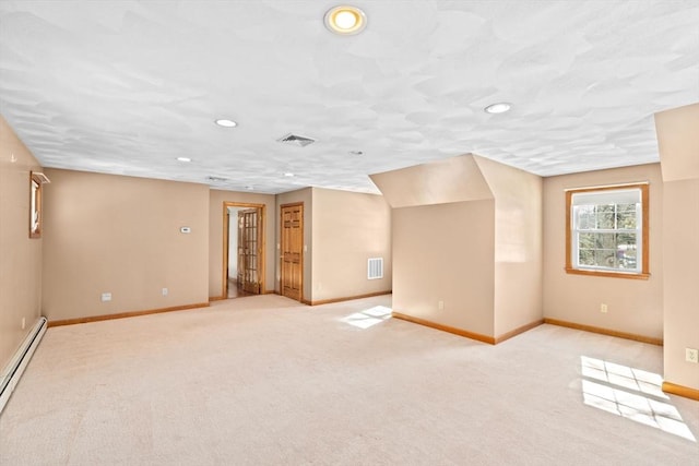 spare room featuring light colored carpet and baseboard heating