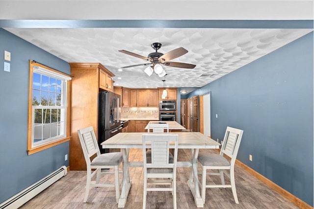 dining space with a baseboard radiator, ceiling fan, and light hardwood / wood-style floors