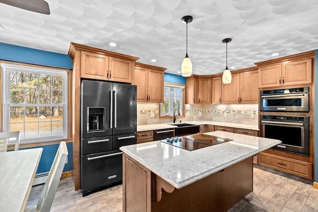 kitchen with decorative light fixtures, a kitchen island, black appliances, light stone countertops, and tasteful backsplash