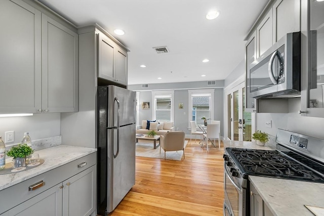 50 Alpine St Unit 2, Somerville, MA 02144 - kitchen featuring appliances with stainless steel finishes, gray cabinets, light wood-style flooring, recessed lighting, and light stone counters
