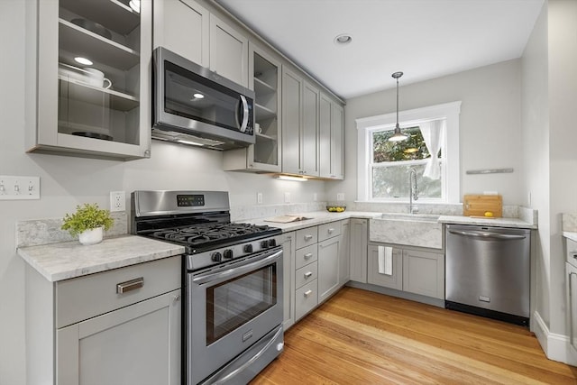 50 Alpine St Unit 2, Somerville, MA 02144 - kitchen with appliances with stainless steel finishes, gray cabinetry, a sink, and light wood-type flooring