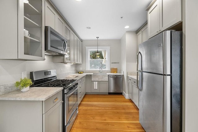 50 Alpine St Unit 2, Somerville, MA 02144 - kitchen featuring stainless steel appliances, gray cabinets, light countertops, light wood-style flooring, and glass insert cabinets