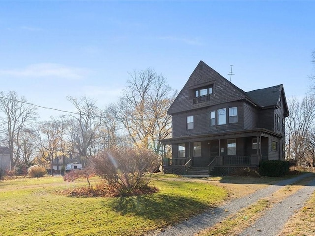 view of front facade featuring covered porch and a front lawn