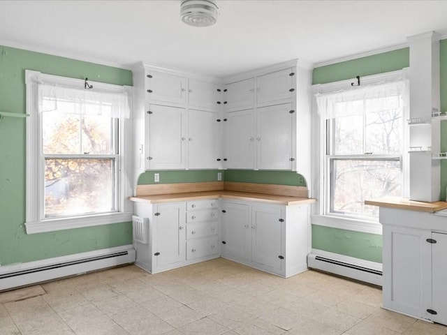 kitchen featuring baseboard heating and white cabinetry