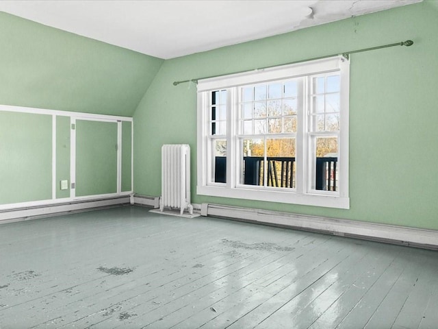 bonus room featuring wood-type flooring, lofted ceiling, radiator, and a baseboard heating unit