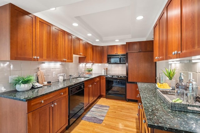 1010 Memorial Dr Unit 3F, Cambridge, MA 02138 - kitchen featuring black appliances, a tray ceiling, decorative backsplash, light wood-type flooring, and recessed lighting