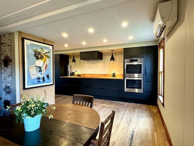 dining area with beamed ceiling, light hardwood / wood-style floors, and a wall mounted air conditioner