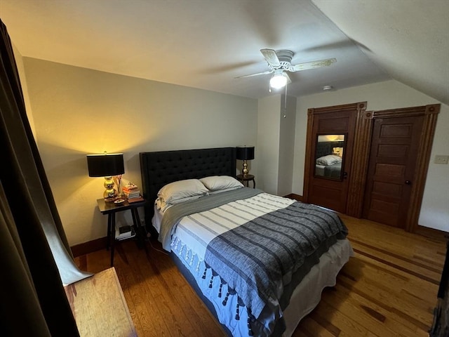 bedroom featuring dark hardwood / wood-style flooring, ceiling fan, and lofted ceiling