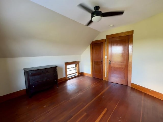 additional living space with ceiling fan, dark hardwood / wood-style flooring, and vaulted ceiling