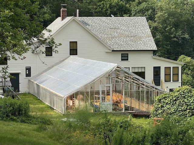 rear view of property with an outdoor structure