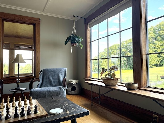 living area with hardwood / wood-style floors and ornamental molding