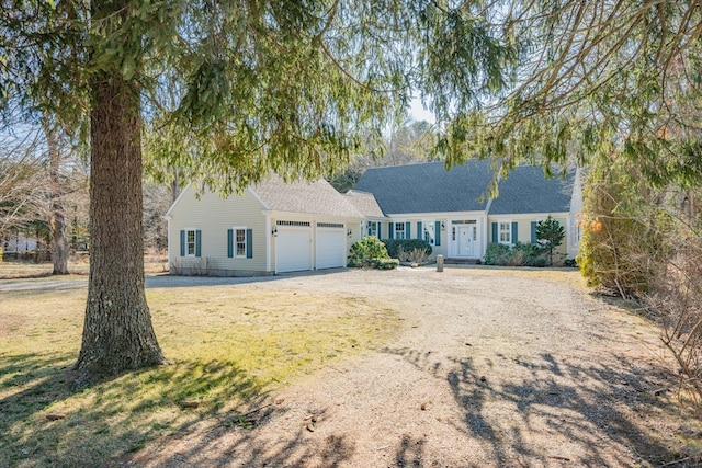 view of front of property featuring dirt driveway and a garage