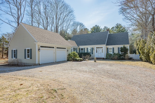 view of front of house featuring roof with shingles, driveway, a chimney, and an attached garage