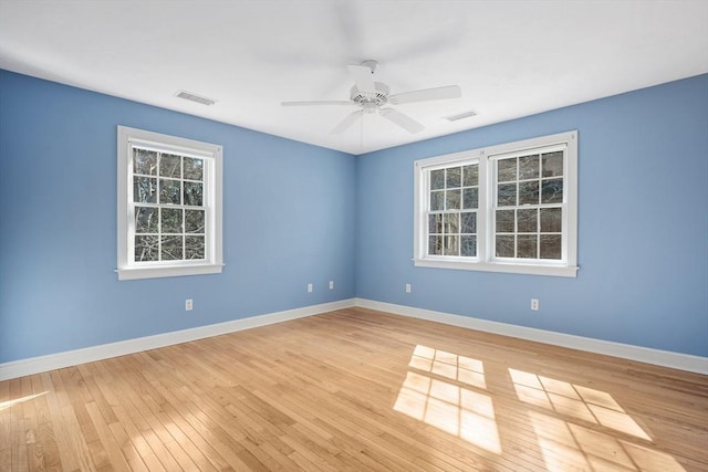 unfurnished room with light wood finished floors, baseboards, visible vents, and ceiling fan