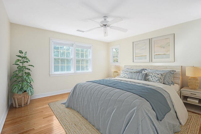 bedroom with light wood-style floors, ceiling fan, and baseboards